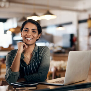 Shot of a young woman using a laptop while working in a cafe